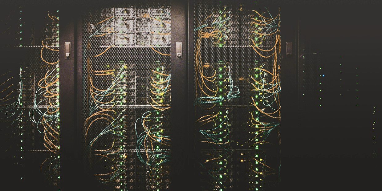 Densely cabled server rack in a darkened comms room